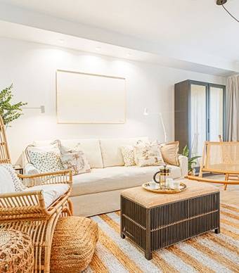 Sala com pavimento cerâmico com efeito de madeira, tapete natural às ricas brancas e cadeira de jardim em madeira
